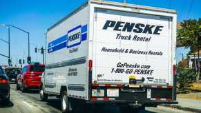 The back of a white Penske rental truck with Indiana license plates on a California highway.