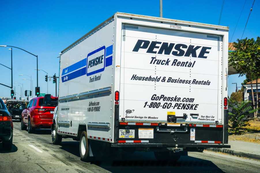 The back of a white Penske rental truck with Indiana license plates on a California highway.