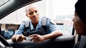 Police officer leans into a window during a traffic stop.