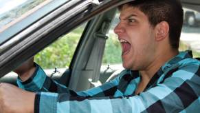 A driver with road rage screams at another motorist.