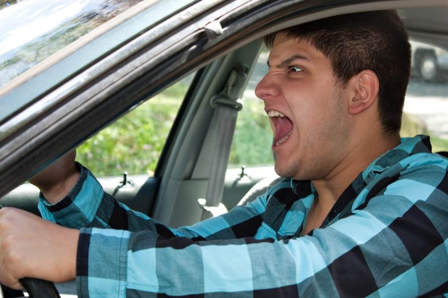 A driver with road rage screams at another motorist.