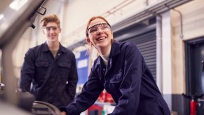 Two shop students working on a car