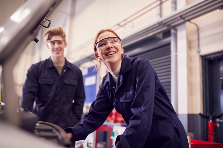 Two shop students working on a car