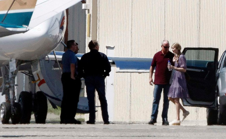 Singer taylor swift walking across the taxi way and to her private jet.