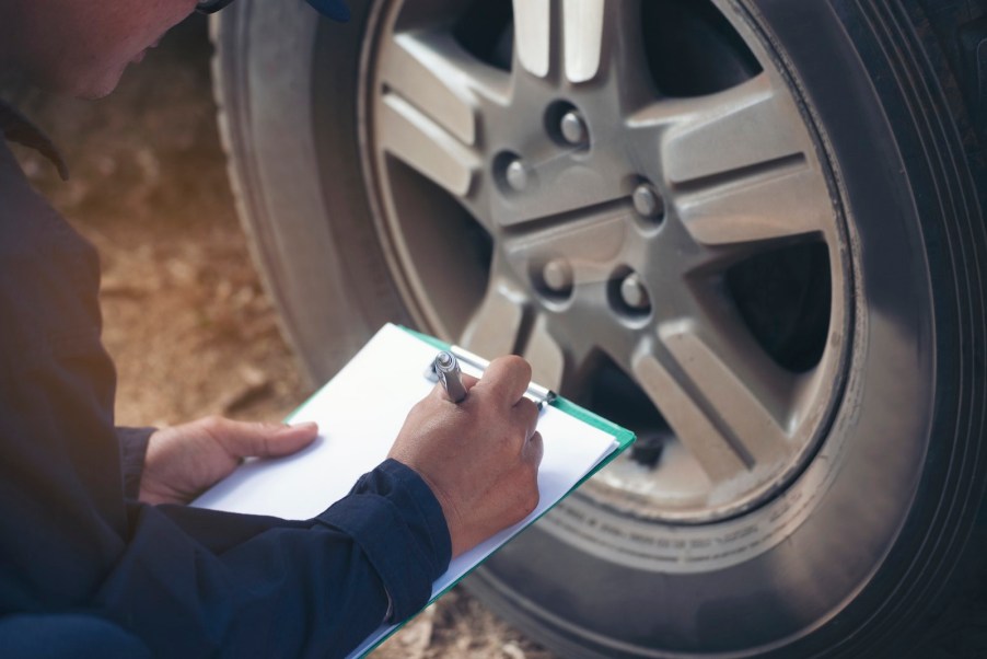 Mechanic checking to see if tires expired by reading tire birth code.