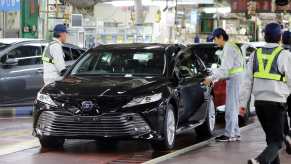 Japanese factory workers finish the assembly of a Toyota Camry