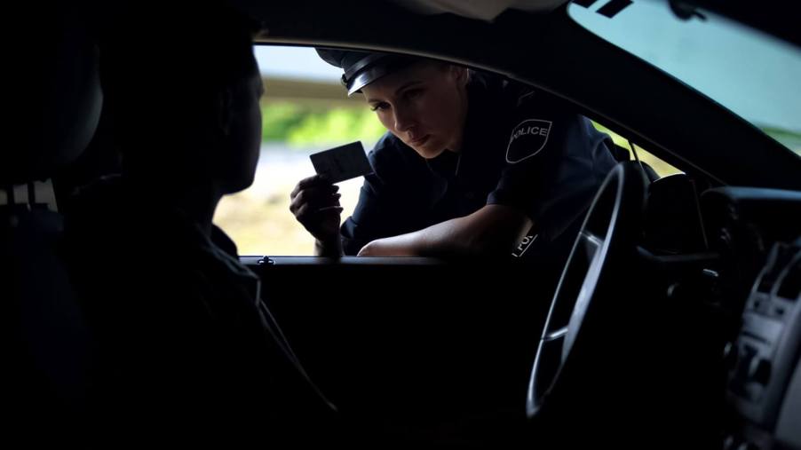 A police officer checks a license during a traffic stop.