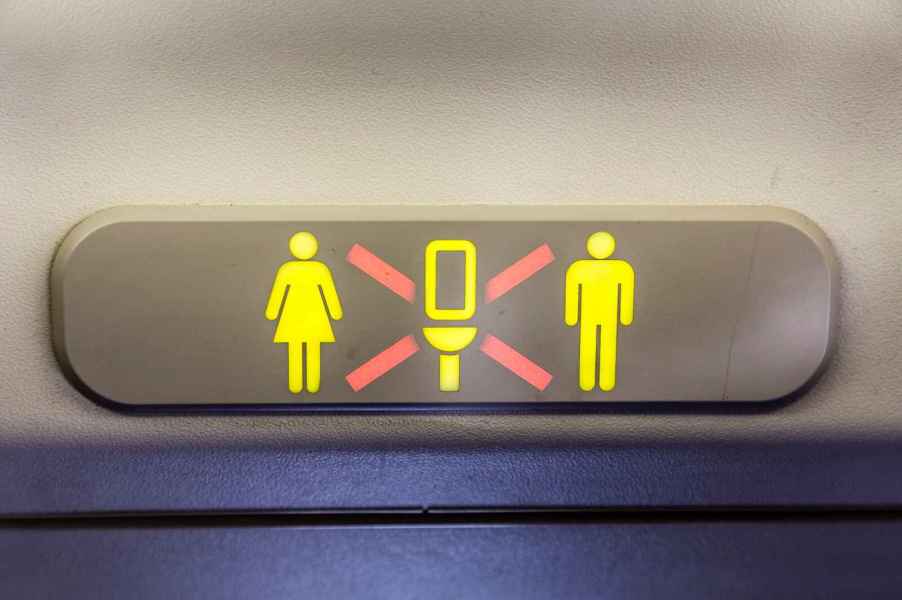 "Airplane bathroom occupied" icon illuminated in close view inside an airplane cabin