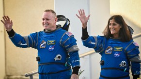 The stranded Boeing Starliner spacecraft crew photographed waving in their blue NASA jumpsuits before launch