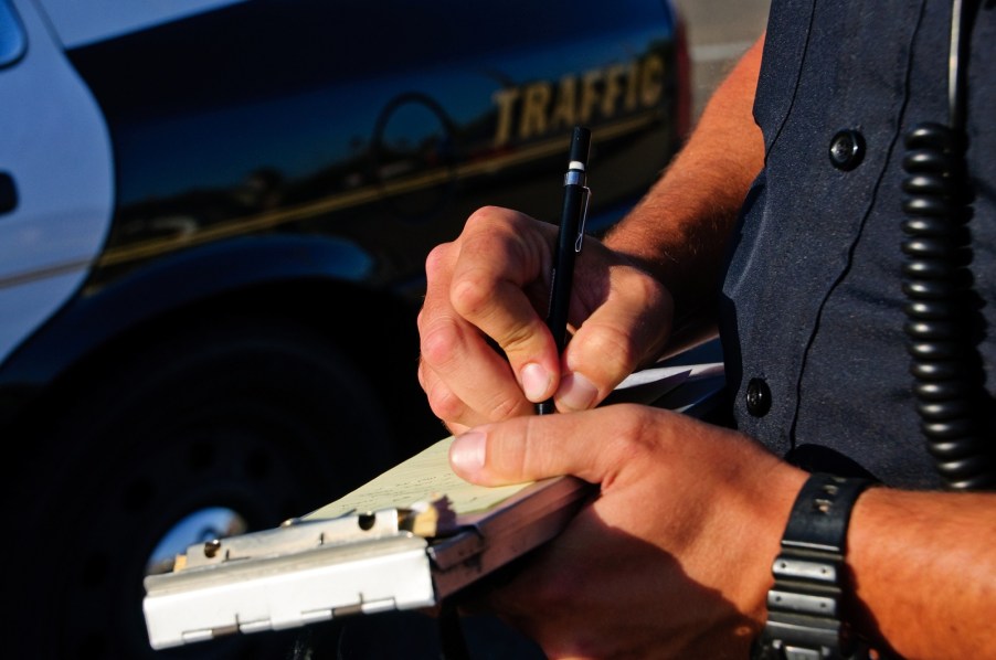 Police officer issuing a traffic violation ticket in close view common driving habits can actually be illegal in many states