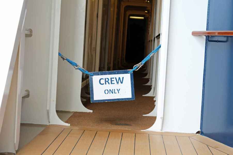 "Crew Only" sign posted in the hallway of a cruise ship.