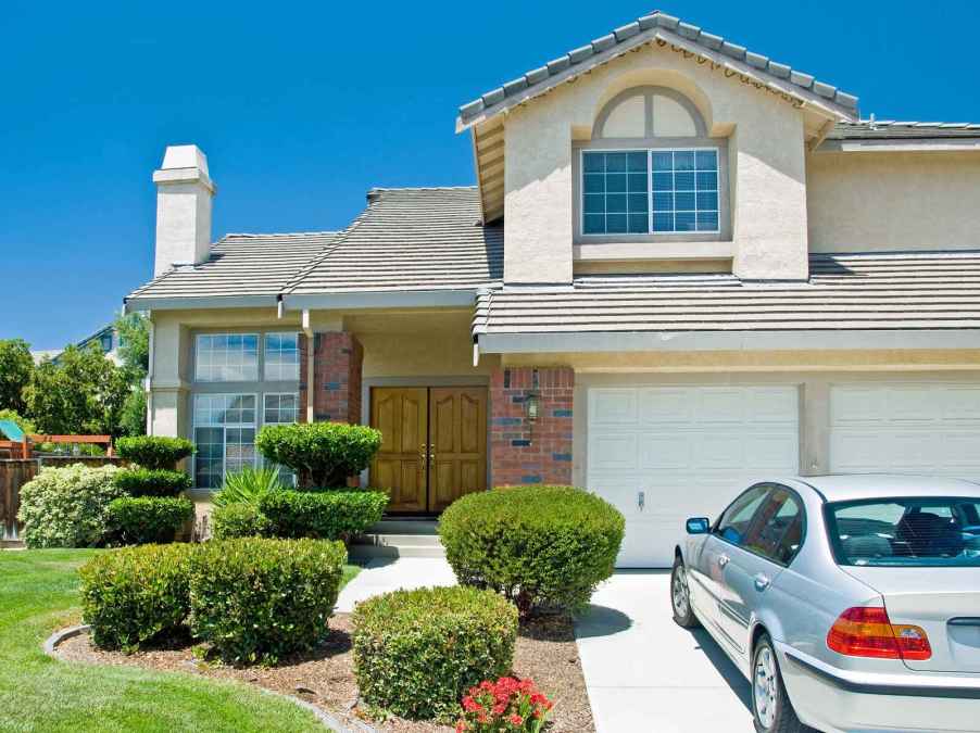 Home with two car garage and BMW parked in driveway, home upgrades can include a replacement garage door which has highest ROI