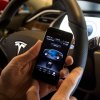 Driver using an iPhone smartphone in a Tesla car