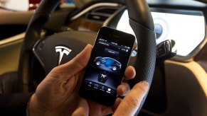 Driver using an iPhone smartphone in a Tesla car