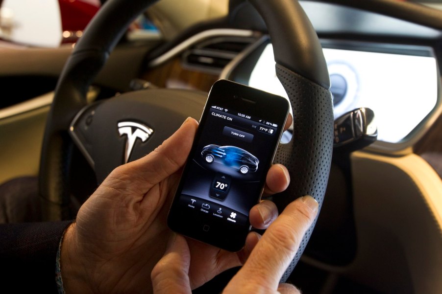 Driver using an iPhone smartphone in a Tesla car