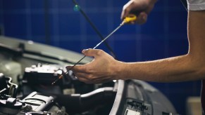 A man using a dipstick to check the oil level