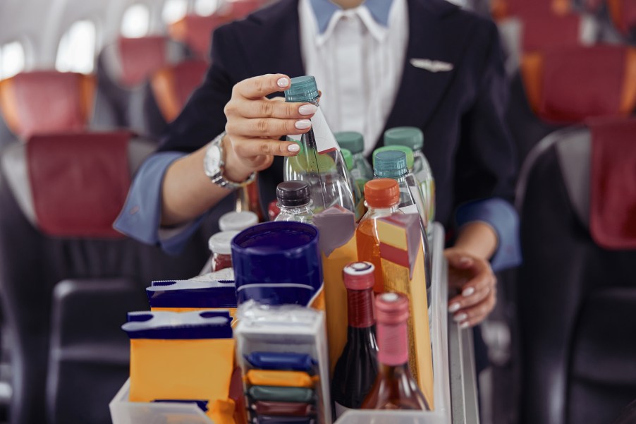 A flight attendant pushing a beverage cart