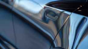 A close view of the left rear door handle on a Tesla EV