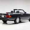 A vintage Mercedes-Benz SL convertible parked in right rear angle view on white floor and background