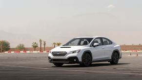 A white Subaru WRX parked on a skidpad.