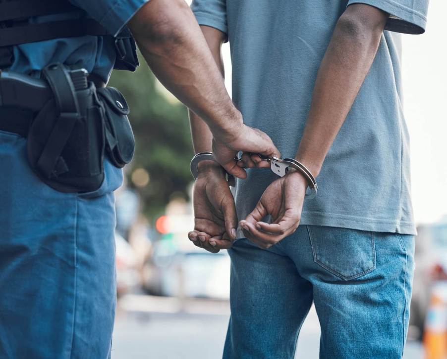 Police officers arrest a driver after searching their car.