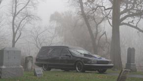 A hearse in a foggy cemetery