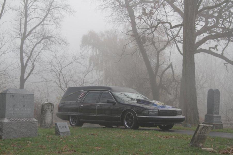 A hearse in a foggy cemetery