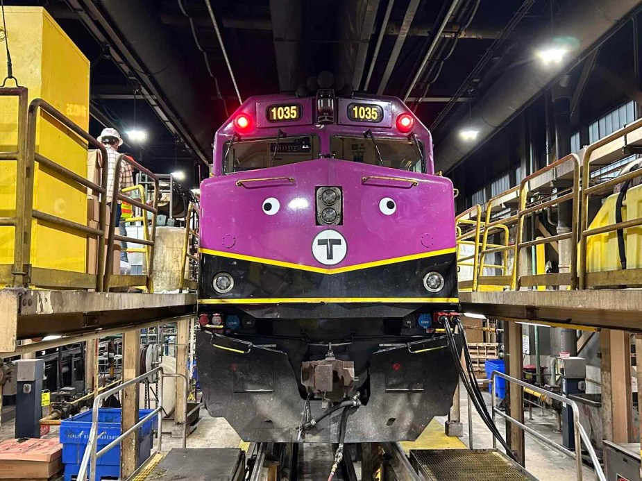 Purple Boston subway train with decorative googly eyes on the front.