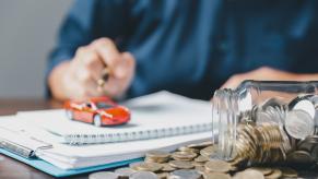 An agent works on car insurance rates as they sort out a policy.