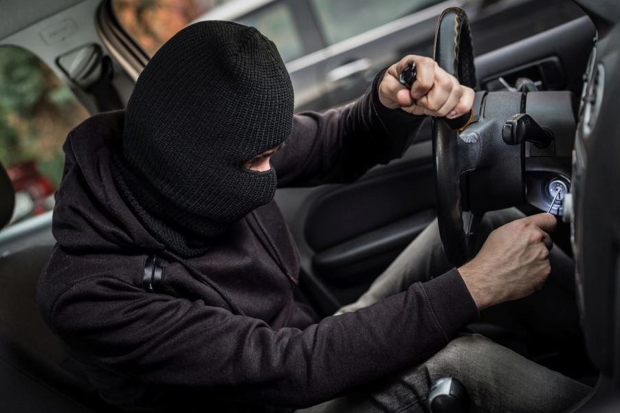 A thief works on a stolen car.