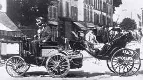 The Count de Dion driving his steam engine, the fastest vehicle in the first auto race through Paris.