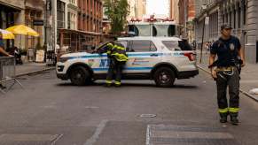 New York Fire Department firefighters check in with NYPD, perhaps to write a ticket, at a scene