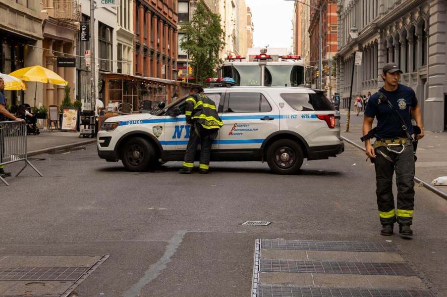 New York Fire Department firefighters check in with NYPD, perhaps to write a ticket, at a scene