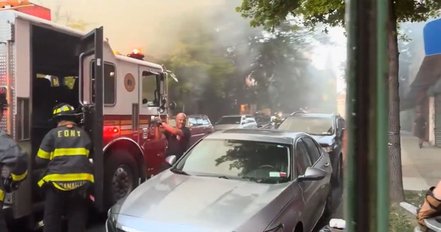 FDNY firefighters smash the windows of a parked Honda Accord.