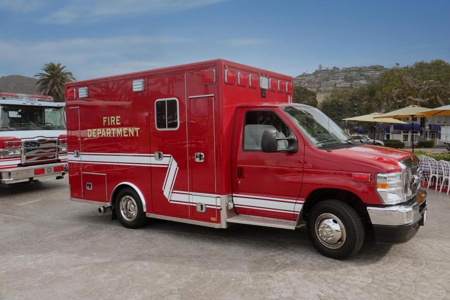 An ambulance driver prepares to drive a bright-red fire department ambulance.