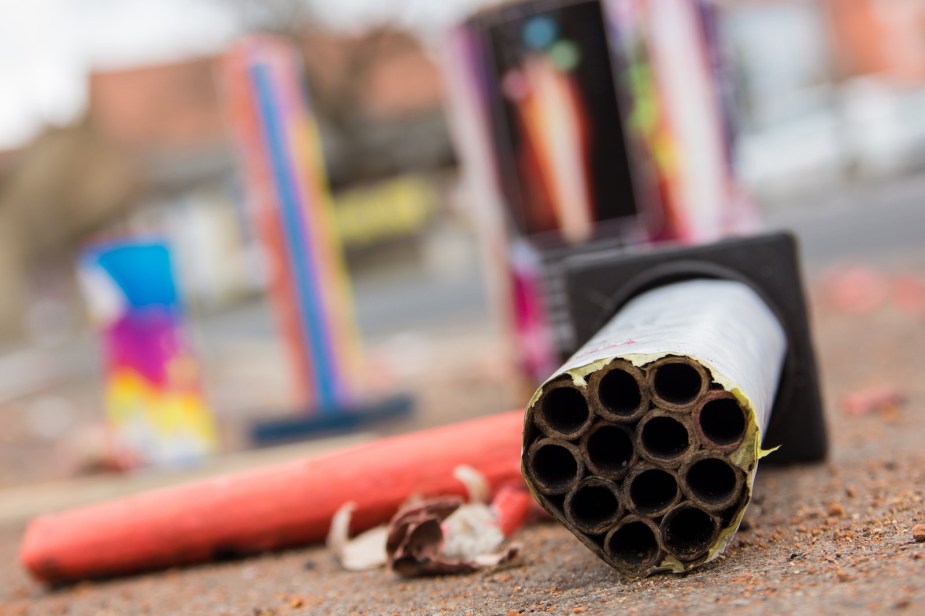 The cardboard husks of spent fireworks laying on the ground.