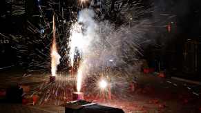 Cardboard boxes of fireworks are lit in an amateur show.