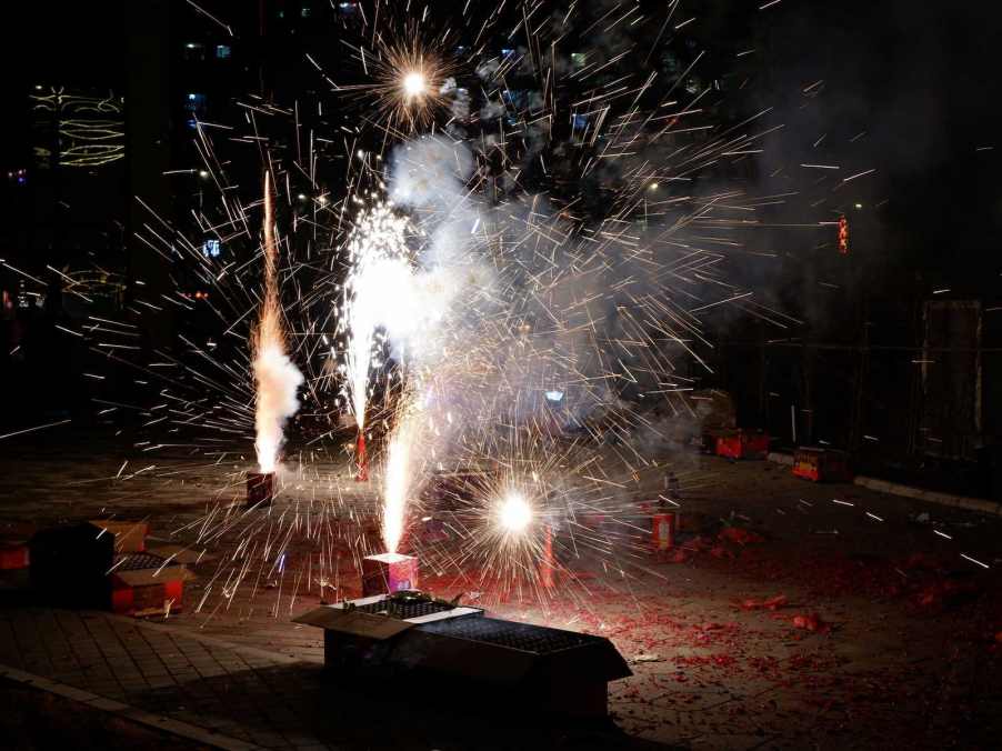 Cardboard boxes of fireworks are lit in an amateur show.