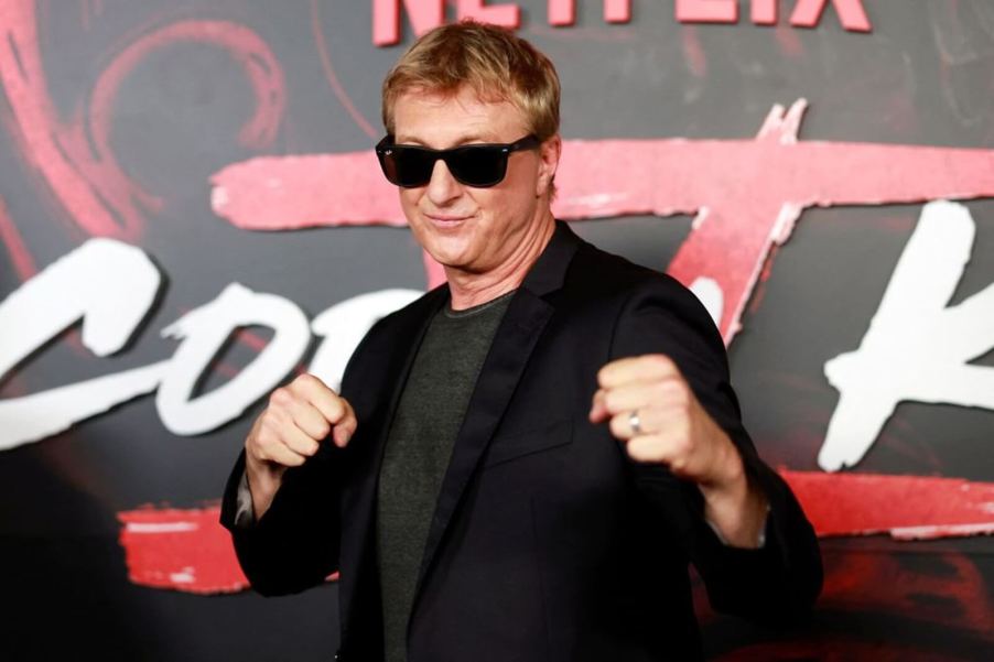 Cobra Kai star William Zabka steps out of his Dodge Challenger and onto the red carpet at a Netflix event.