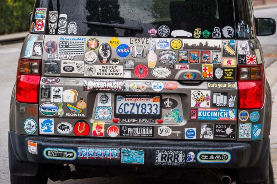 A Honda Element covered in decals like an honor roll bumper sticker and an Amoeba Records decal.