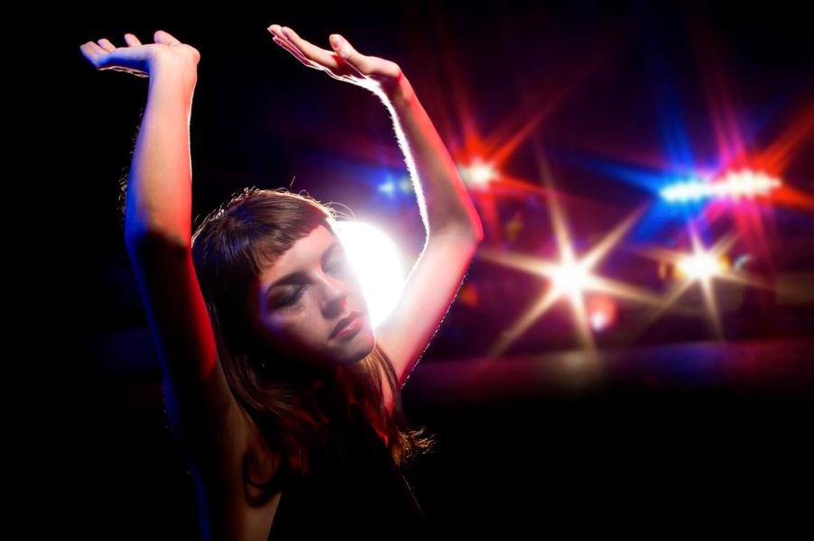 A woman holds here hands up as police prepare to arrest her for a DUI.