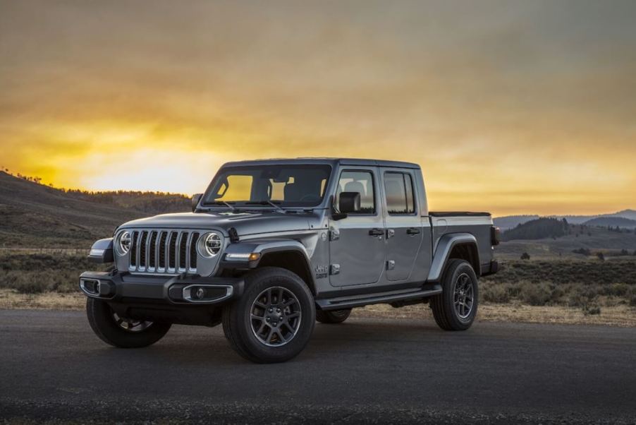 A gray Jeep Gladiator parks on a pad at sunrise.