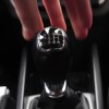 Driver reaches for a manual transmission gear shift.