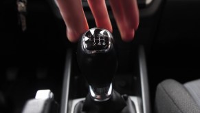 Driver reaches for a manual transmission gear shift.