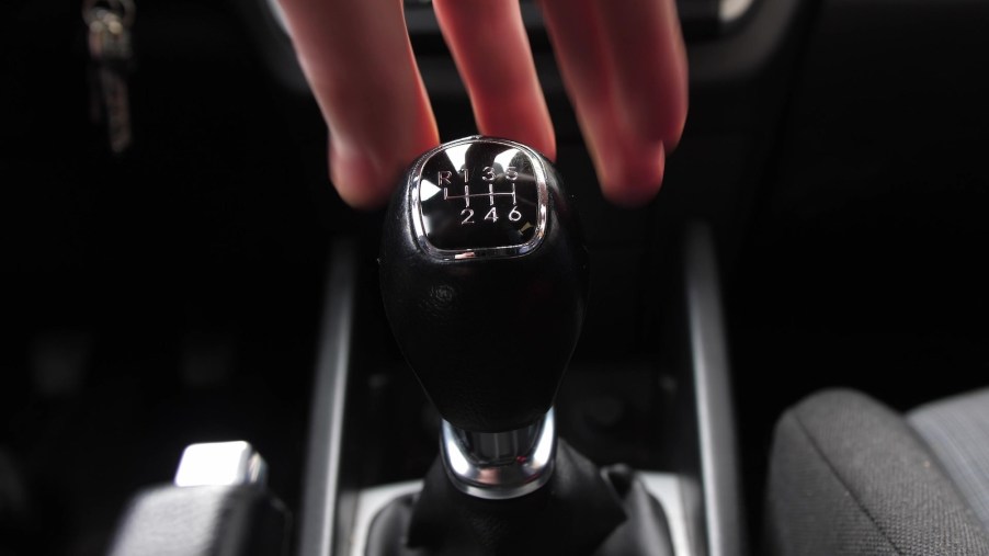 Driver reaches for a manual transmission gear shift.