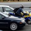 A motorcycle riding between fast-moving highway traffic as he splits lanes in California