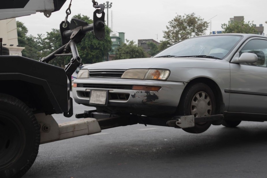 Tow truck pulls an older sedan