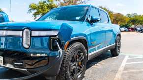 blue electric Rivian truck plugged into a charging cable.