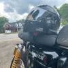 A SHOEI RF-SR motorcycle helmet with a Cardo PACKTALK EDGE Bluetooth unit on a Triumph Thruxton R.