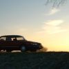 A Saab 900 Turbo shows off its merit among sports cars at sunset.